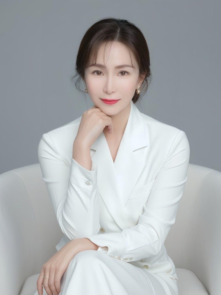 Cheng Xiaoxiao, seated in a white suit, one hand resting under her chin.